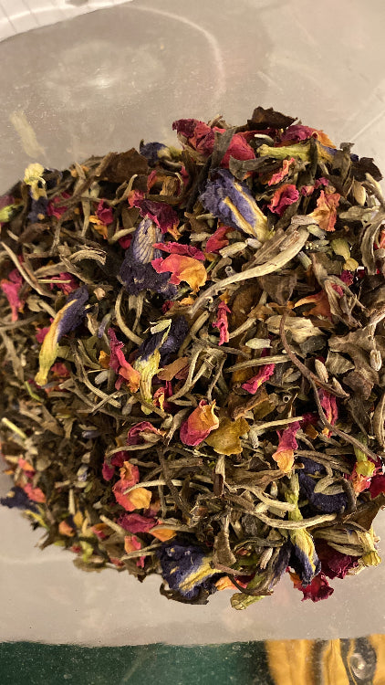 A variety of dried herbs and flowers mixed together, intended for use in a herbal tea.