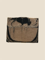 Marbled brown and black soap bar on a beige background
