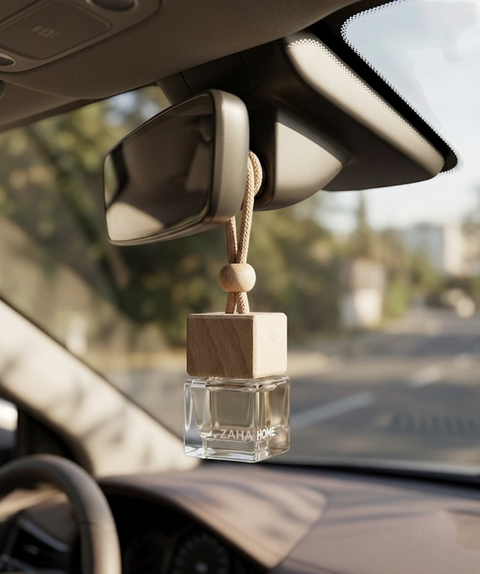 Car air freshener hanging from the rearview mirror with a blurred outdoor background