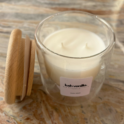 Glass candle with wooden lid on a textured surface