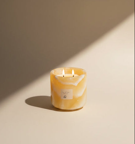 Yellow marbled candle with a label on a beige background