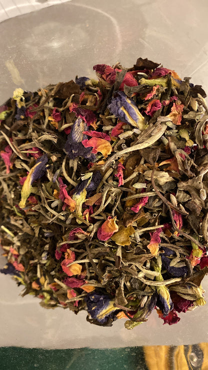 A variety of dried herbs and flowers mixed together, intended for use in a herbal tea.