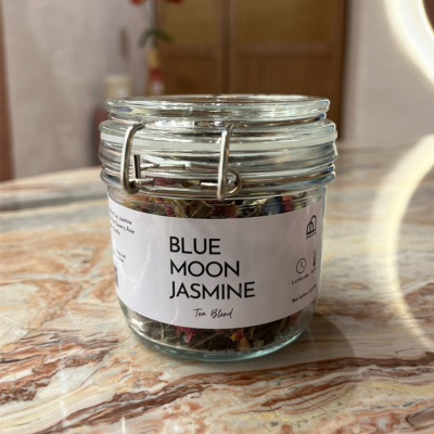 Jar of 'Blue Moon Jasmine' tea blend on a marble surface