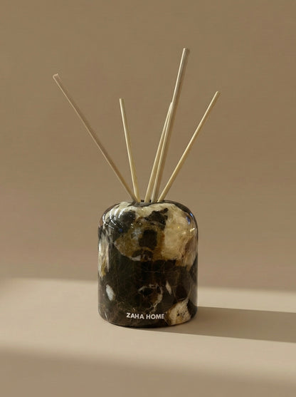 Decorative diffuser with marble pattern and 'Zaha Home' branding on a beige background