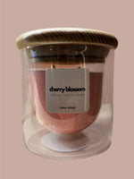 A double-walled glass candle with a wooden lid and a label that reads 'Serenity', featuring a clear wax candle inside.