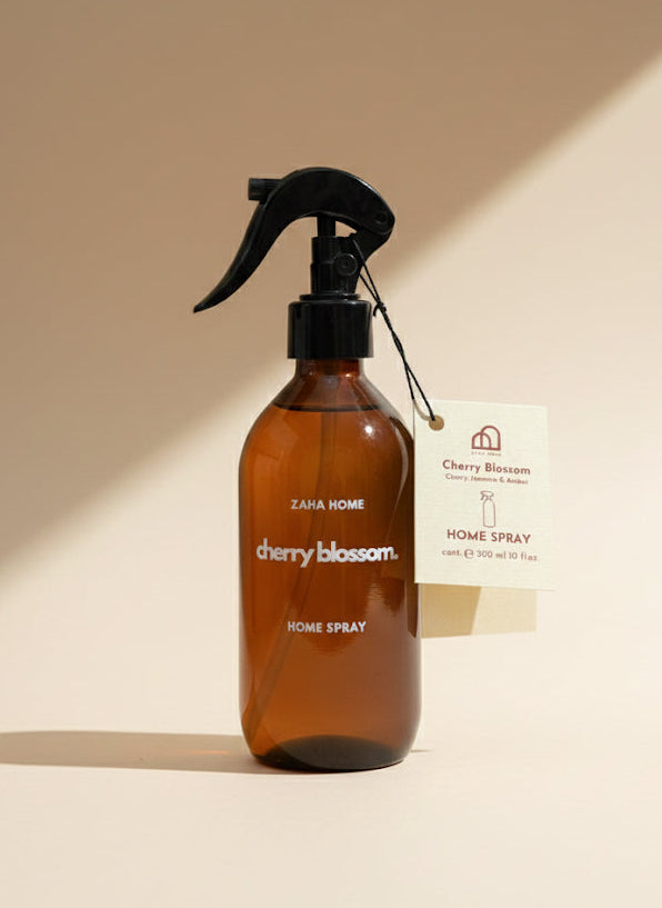 Brown spray bottle labeled 'cherry blossom' on a beige background