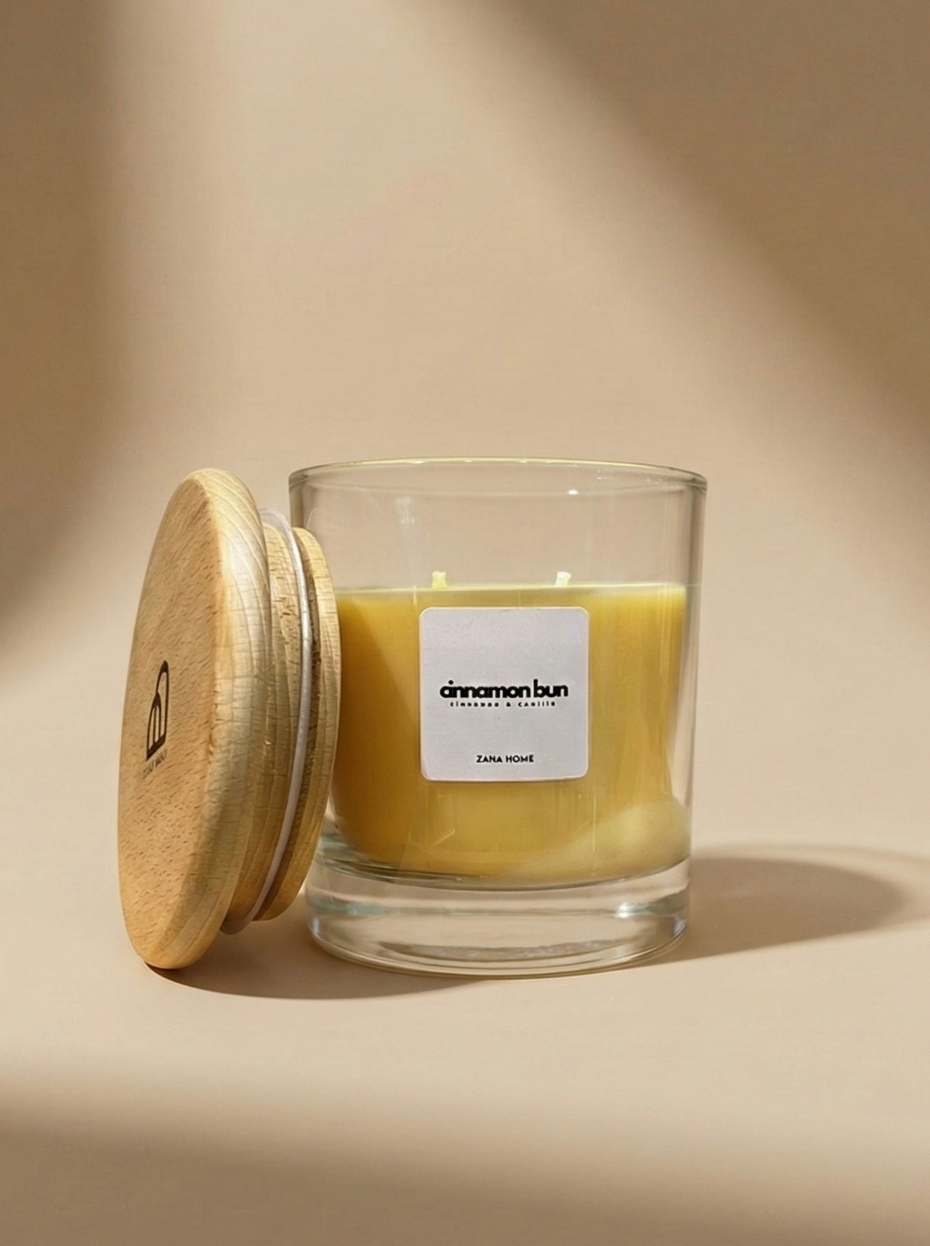 Glass candle with wooden lid on a beige background