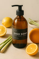 Brown dish soap bottle with pump on a beige surface with lemons and limes.