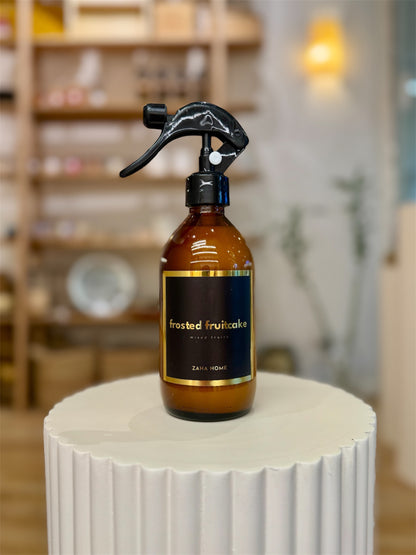 Brown fabric and home spray bottle with black nozzle on a white surface, blurred shelves in the background