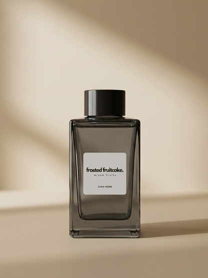 Dark glass perfume bottle with a label on a beige background