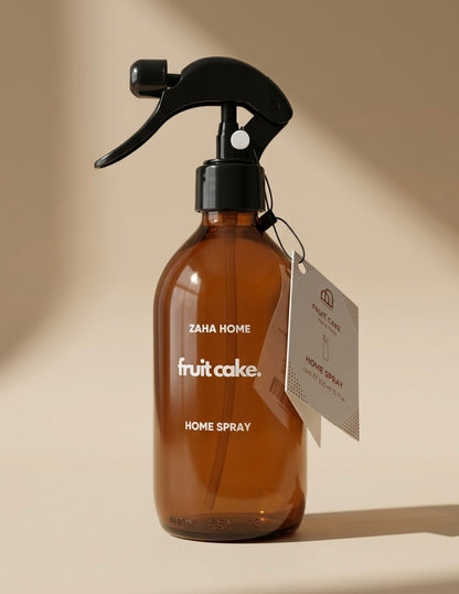 Brown spray bottle labeled 'fruit cake' with a tag on a beige background