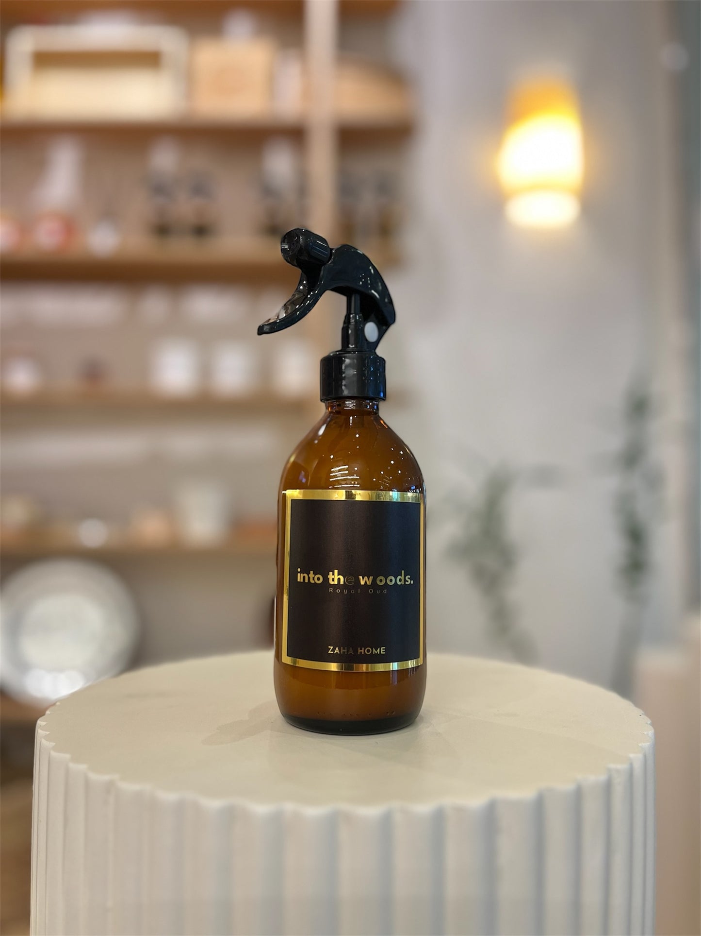 Brown spray bottle with black spray nozzle on a white surface.