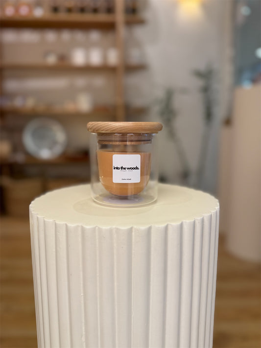 Jar with wooden lid on a white cylindrical surface in a store setting