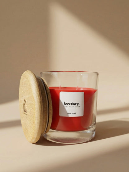 Red candle in a glass jar with a wooden lid on a beige background