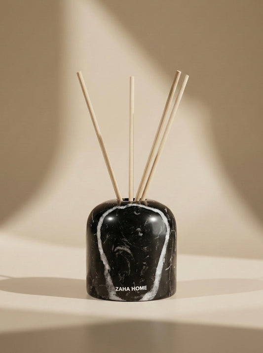 Black marble-patterned diffuser with wooden sticks on a beige background