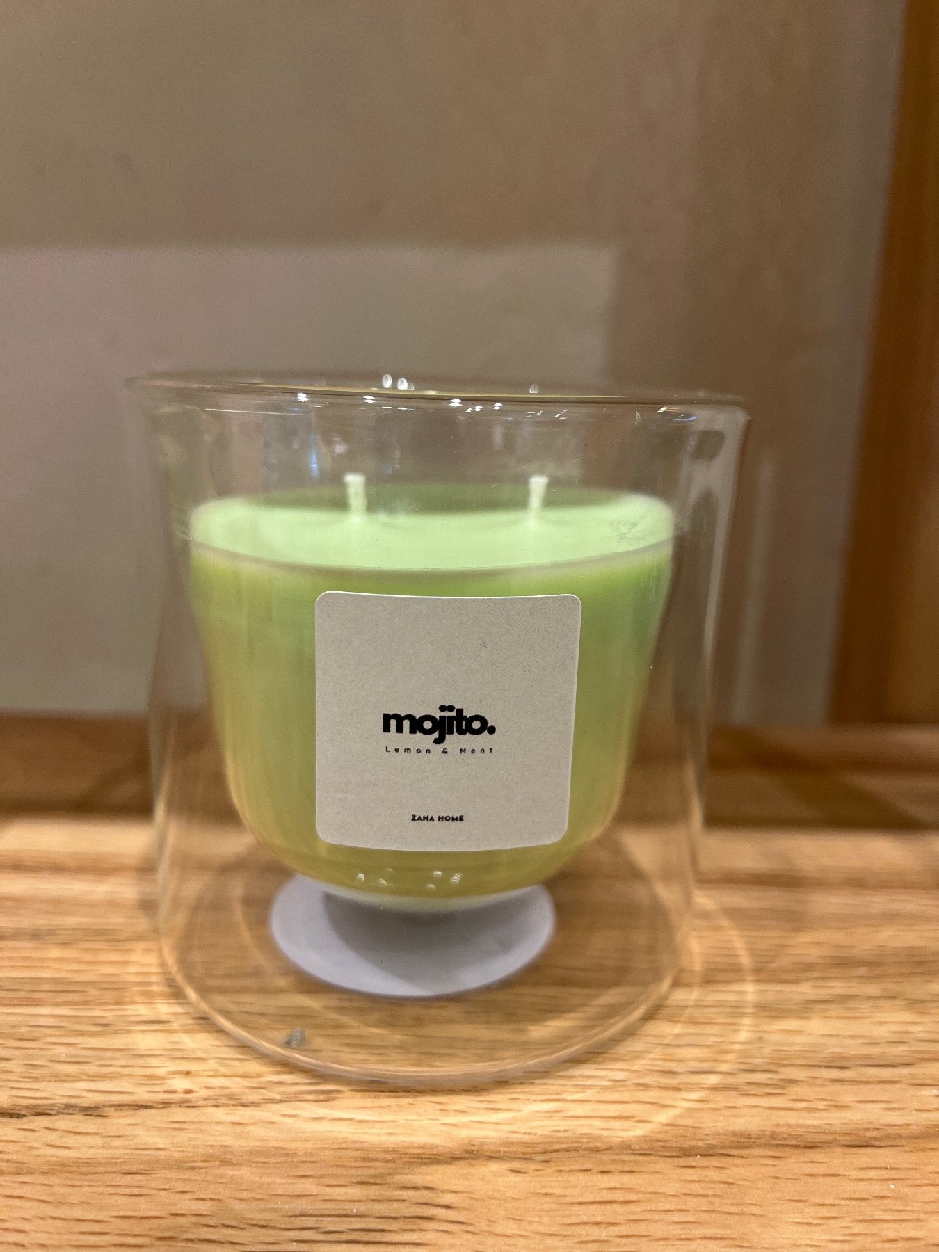A double-walled glass candle with a wooden lid and a label that reads 'Serenity', featuring a clear wax candle inside.