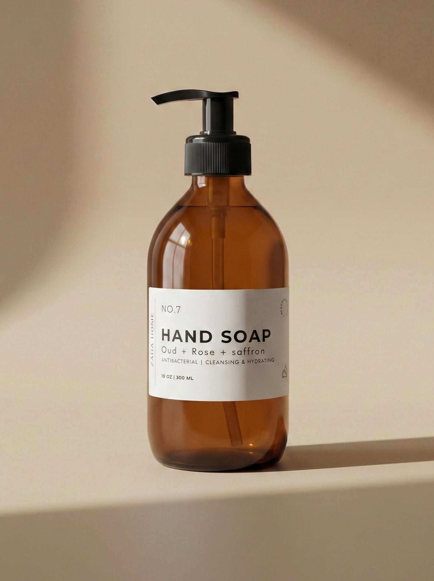 Brown glass hand soap bottle with pump on a beige background