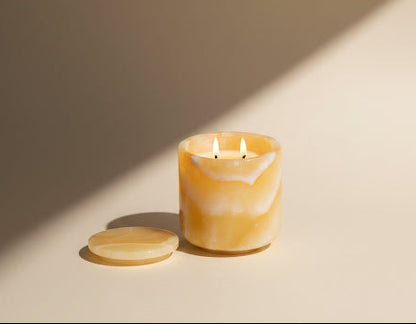 Marbled candle with wooden lid on a beige background
