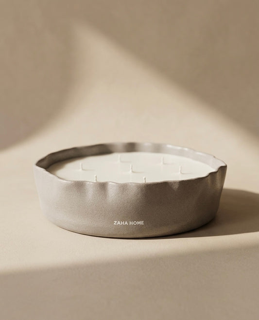 Scented candles in a decorative bowl with a textured surface on a beige background, featuring the brand 'Zaha Home'.