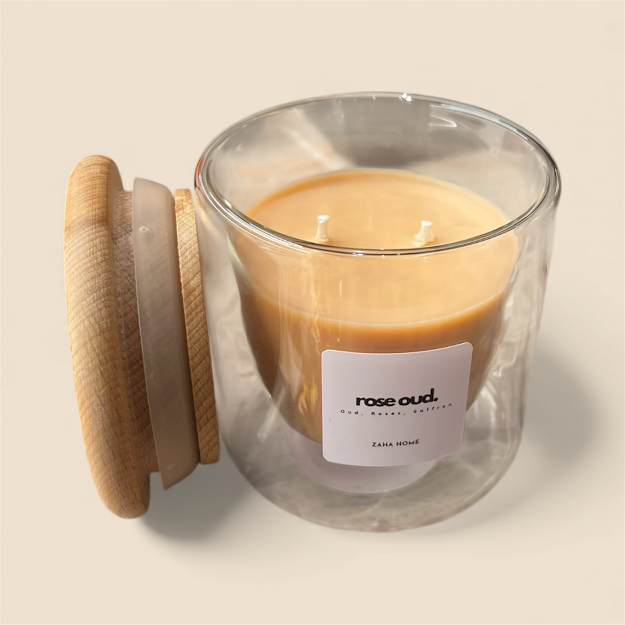 Glass candle with wooden lid and 'rose oud' label on a beige background