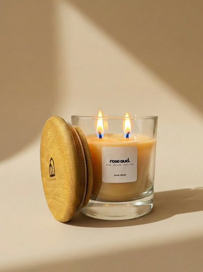 Candle in a glass jar with a wooden lid on a beige background