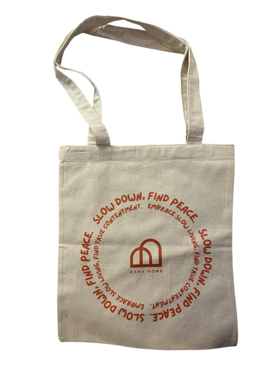 Beige tote bag with red text and logo on a white background