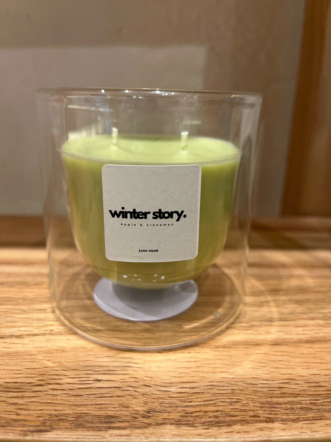 A double-walled glass candle with a wooden lid and a label that reads 'Serenity', featuring a clear wax candle inside.